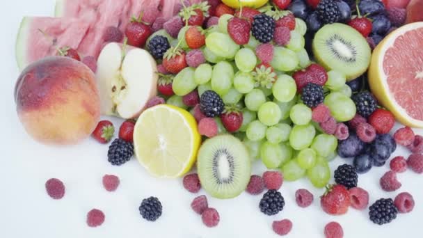 Gyönyörű vegyes bogyós gyümölcsök és a gyümölcs fehér háttér. Zárja be az egészséges táplálkozás. 4k - Felvétel, videó