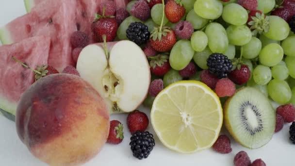 Krásné smíšené bobule a ovoce na bílém pozadí. Zdravé jídlo zblízka. 4k - Záběry, video