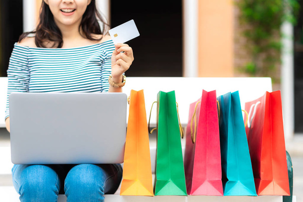 Rajattu kuva hymy nainen nauttia ostoksia verkossa tilalla luottokortti ostoskassi
  - Valokuva, kuva
