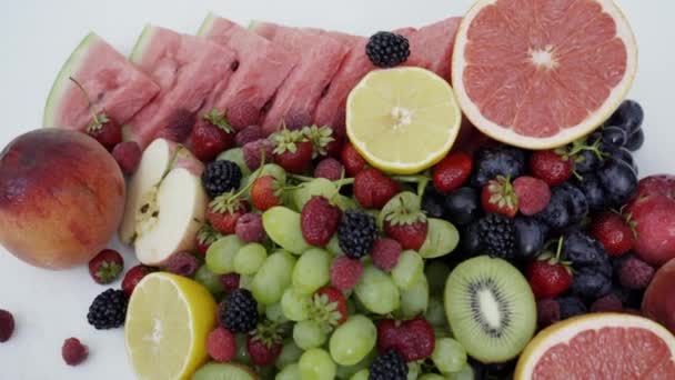 Mooie gemengde bessen en vruchten op witte achtergrond. Close-up van gezonde voeding. 4k - Video