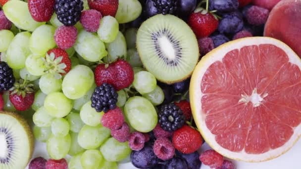 Gyönyörű vegyes bogyós gyümölcsök és a gyümölcs fehér háttér. Zárja be az egészséges táplálkozás. 4k - Felvétel, videó