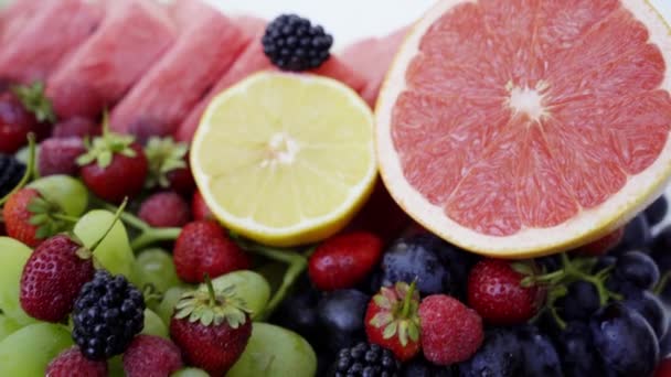 Kauniita marjoja ja hedelmiä valkoisella taustalla. Sulje terveellistä ruokaa. 4K
 - Materiaali, video