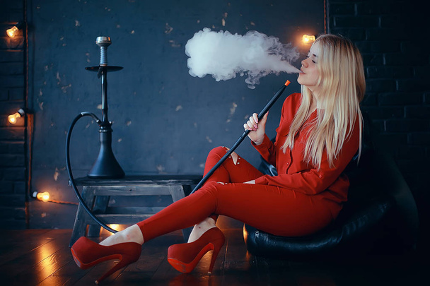 attractive young blonde woman in red clothes smoking hookah - Fotó, kép