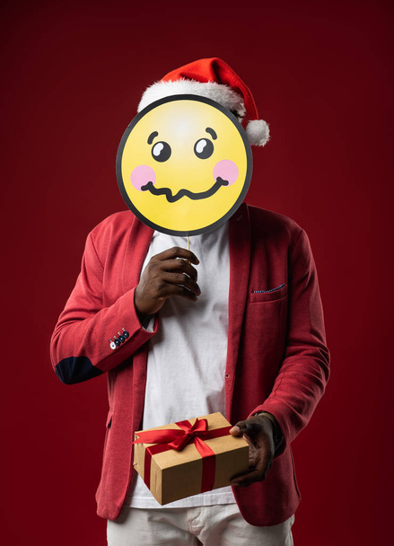 Guy holding present and carton icon of confused face - Fotoğraf, Görsel