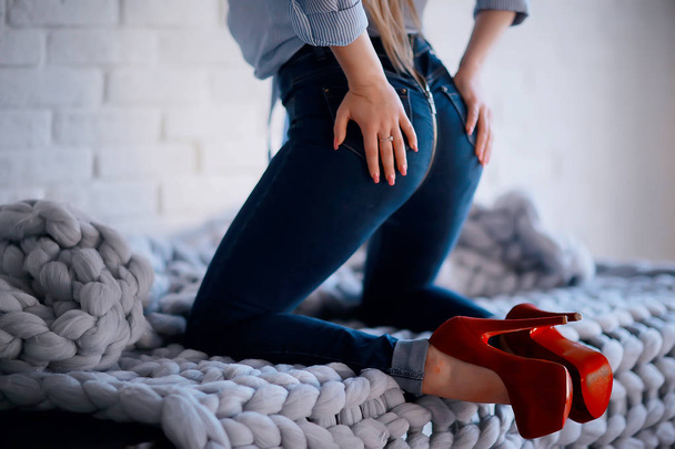 привлекательная девушка в джинсах и красных туфлях на высоких каблуках
 - Фото, изображение