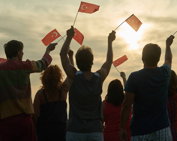 Achteraanzicht mensen verhogen van Turkse vlaggen. - Foto, afbeelding