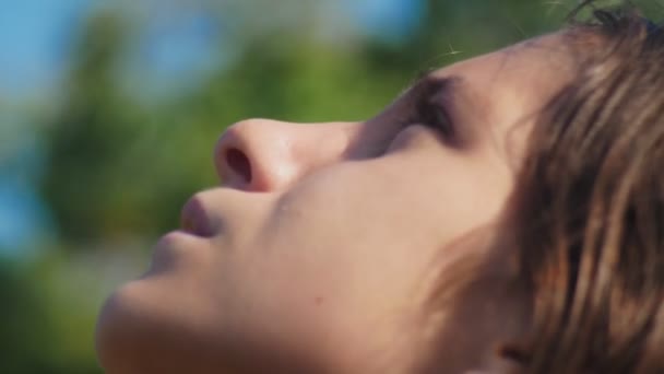close-up. girl teenager looking up at the sky outdoors. face in profile. 4k. - Filmmaterial, Video