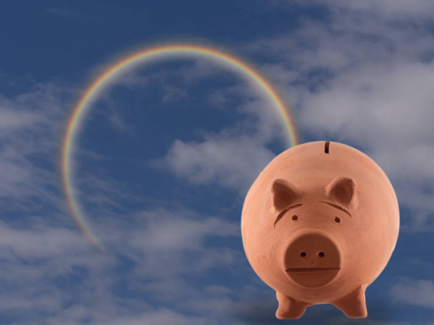 Коробка для свиней Terracotta з хмарним небом та веселкою. Управління грошима, інвестиційна концепція. Ака скарбничка
. - Фото, зображення