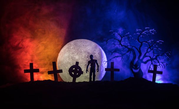 Scary view of zombies at cemetery dead tree, moon, church and spooky cloudy sky with fog, Horror Halloween concept. Toned - Photo, Image
