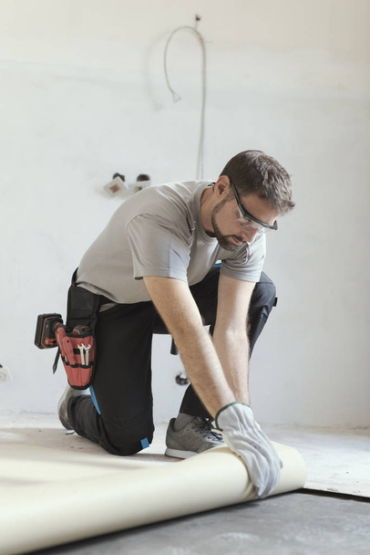 Professional contractor removing an old linoleum flooring: home renovation concept - 写真・画像