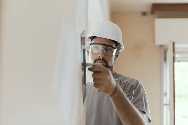 Professional craftsman applying plaster with a trowel, home renovation concept - Φωτογραφία, εικόνα