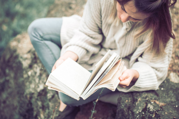 Młoda dziewczyna w ciepły sweter czyta książkę o natura widok z góry, koncepcja, Rozrywka i hobby - Zdjęcie, obraz