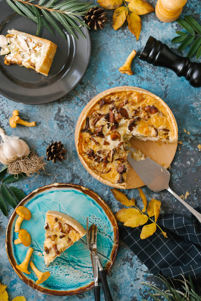 Slice of fresh quiche with wild mushrooms served on blue plate over stone background - Foto, Bild