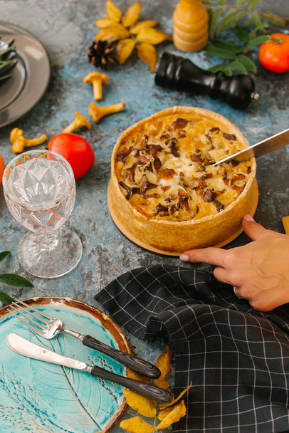 Woman cutting slice of fresh quiche with wild mushrooms - Photo, Image