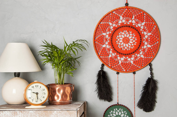 Orange dream catcher in bedroom interior on gray textured background. Bedroom decor and copy space for text - Photo, Image