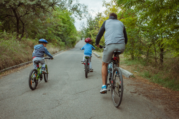 Papa und Kinder haben Spaß beim Fahrradfahren in der Natur - Foto, Bild