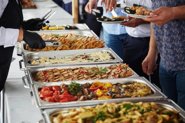 muži v oblecích výběr potravin na hostině - Fotografie, Obrázek