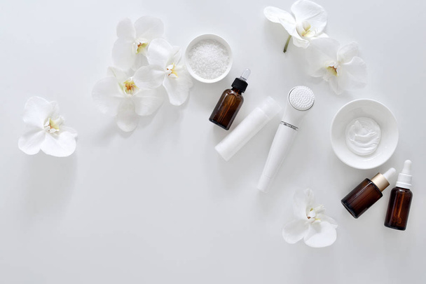 Wellness-Hintergrund mit Gesichtsreinigung oder Massage-Gadget und Kosmetikprodukten für die tägliche Hautpflege, flache Lage, Platz für einen Text - Foto, Bild
