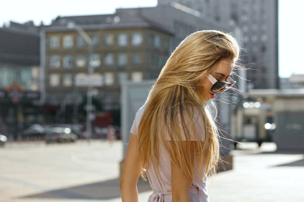 Portrait de mode de belle jeune femme en lunettes de soleil marchant dans la rue. Espace vide
 - Photo, image