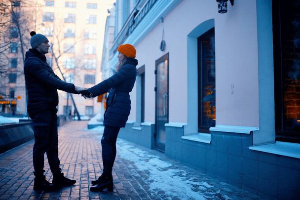 young man and woman walking in winter city, romantic happy couple  - Фото, зображення