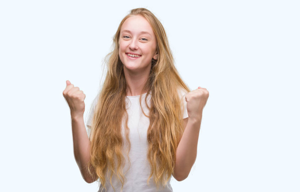 Adolescente rubia gritando orgullosa y celebrando la victoria y el éxito muy emocionada, animando la emoción
 - Foto, Imagen