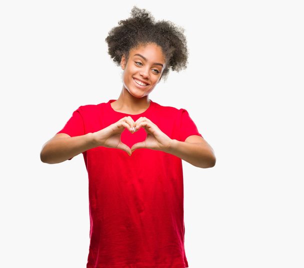 Young afro american woman over isolated background smiling in love showing heart symbol and shape with hands. Romantic concept. - Foto, immagini