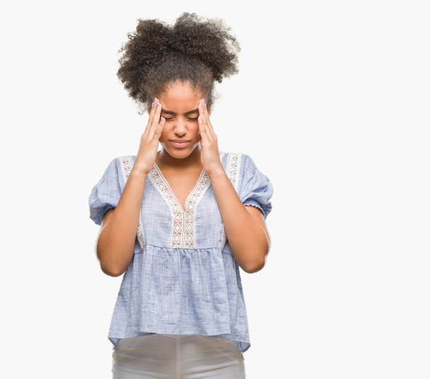 Молодая афро-американка на изолированном фоне с рукой на голове от боли в голове, потому что стресс. Страдания от мигрени
. - Фото, изображение