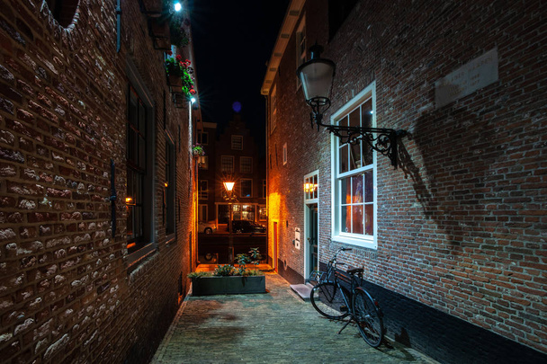 Részletek a utcák, házak, sikátorok és csatornák, a régi város Alkmaar Észak-Hollandia. Szépen kivilágított város látnivalóit és helyszíneit, fényképezett az este és az éjszaka. - Fotó, kép