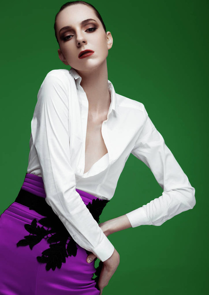 Beautiful fashion model wearing purple pants and white shirt on green background - Foto, Imagem
