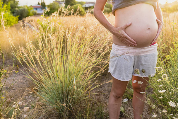 Bauch einer schwangeren Frau auf dem Land - Foto, Bild