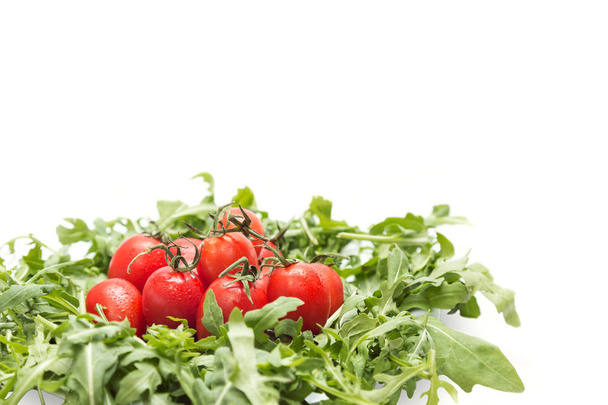 Сладкие помидоры черри со свежей руколой изолированы
 - Фото, изображение