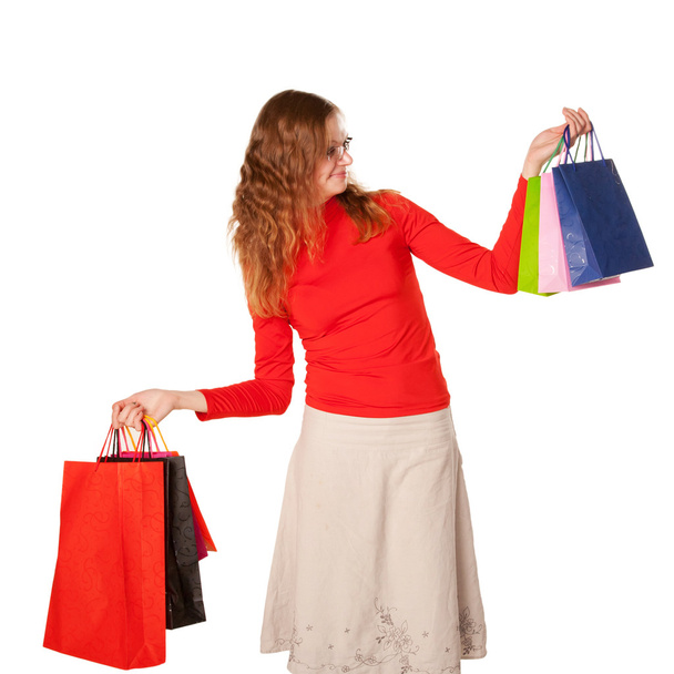 Shopping woman in glasses holding many shopping bags - Фото, изображение