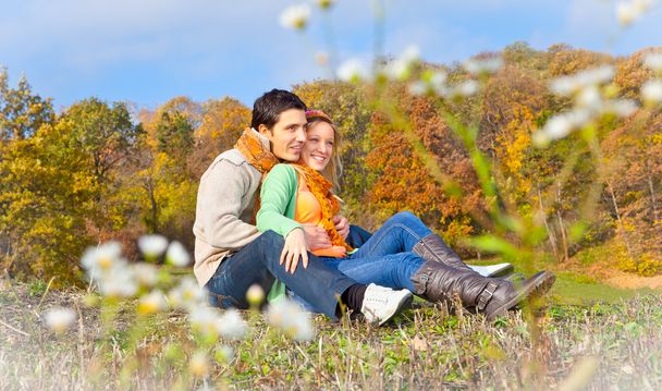Солодка пара сидить на пагорбі на осінньому пейзажі
 - Фото, зображення