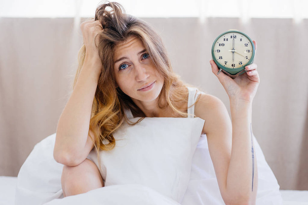 Shocked young woman waking up with alarm - Photo, image