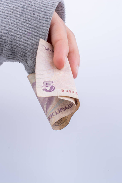Hand hält 5 türkische Lira Banknote auf weißem Hintergrund - Foto, Bild