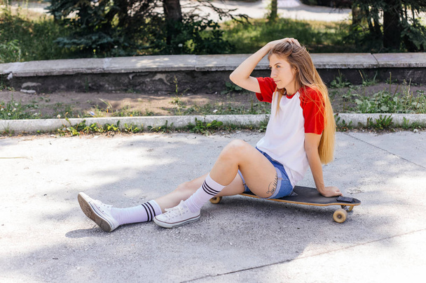 Beautiful skater woman riding on her longboard in the city - Foto, Imagen
