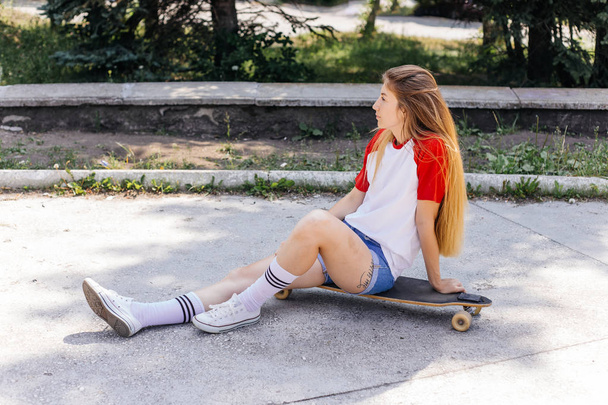 Beautiful skater woman riding on her longboard in the city - Photo, Image