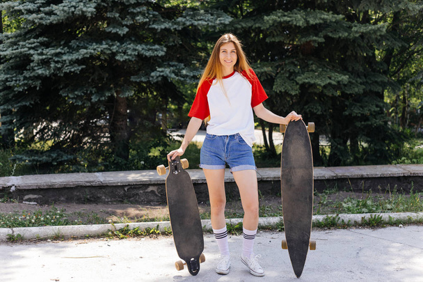 Beautiful skater woman riding on her longboard in the city - 写真・画像