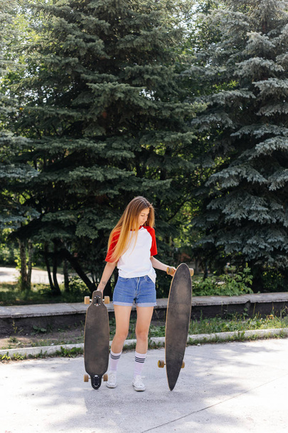 Beautiful skater woman riding on her longboard in the city - Photo, Image