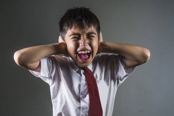 dramatic portrait of young desperate and abused schoolboy screaming and crying victim of bullying and abuse at school isolated on blackboard background in bullied child problem - Foto, imagen