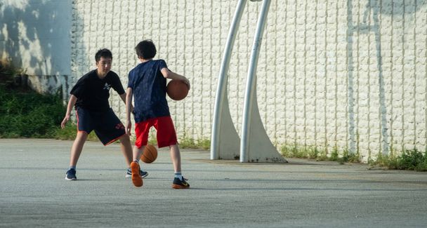 Tokio, Japonia - 10 sierpień 2018 r. japoński chłopców gry w koszykówkę w podmiejskiej dzielnicy Tokio. - Zdjęcie, obraz