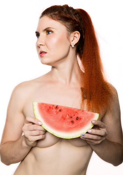 Beautiful nude redhead woman holding a slice of watermelon. concept of healthy eating - Photo, image