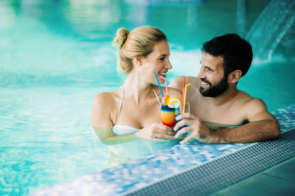 Happy attractive couple relaxing in spa swimming pool - 写真・画像