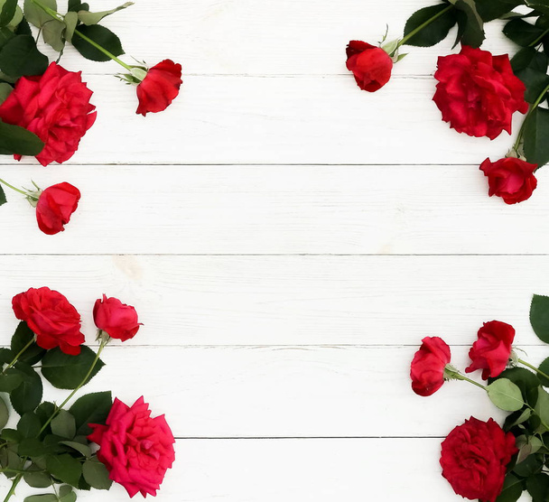 Flowers background . Bouquet frame of a beautiful red roses  on white wooden background. top view. Copy space - Fotografie, Obrázek