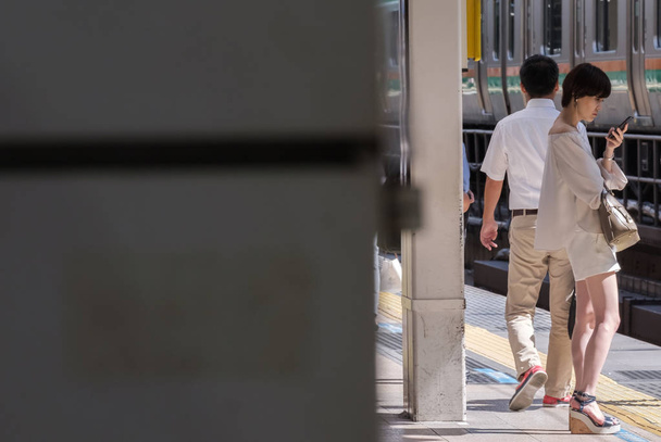 2018 年 8 月 17 日 - 東京都。東京駅で、スマート フォンと日本の女の子. - 写真・画像