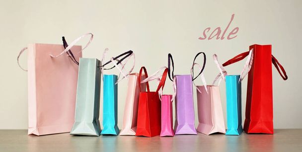 eine Reihe unterschiedlicher farbenfroher Einkaufstüten auf weißem Hintergrund. Verkauf, Geschenke, Feiertage. Schönheits- und Modekonzept - Foto, Bild