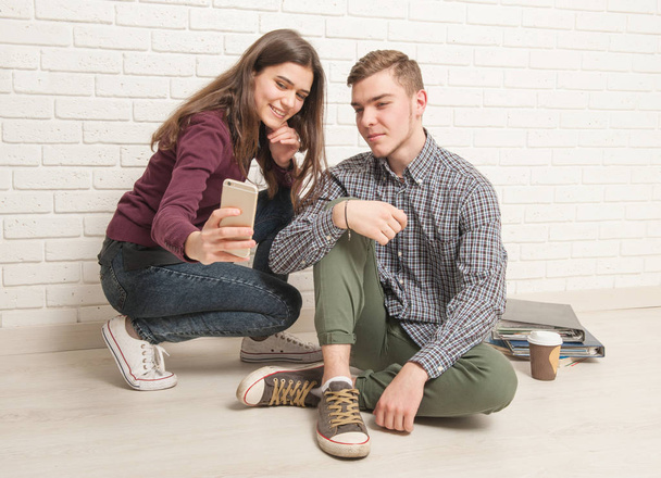 Facet i dziewczyna studenci siedzą na podłodze - Zdjęcie, obraz