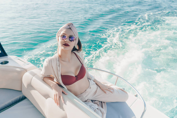 une fille élégante de luxe avec des lunettes de soleil nage dans la mer des Caraïbes, profite de vacances
 - Photo, image