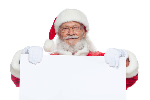Christmas. Good Santa Claus in white gloves holds a blank white cardboard. Place for advertising, for text, empty space. Copy-paste. Isolated on white background. - Photo, Image