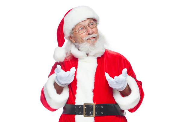 Christmas. Good Santa Claus in white gloves shows faces, grimaces, shows his tongue. Not standard behavior. Isolated on white background. - Foto, Bild